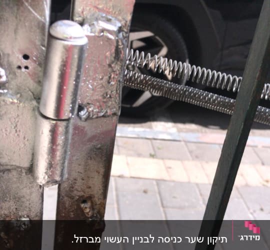 ציר מתכת עם קפיץ על שער ברזל